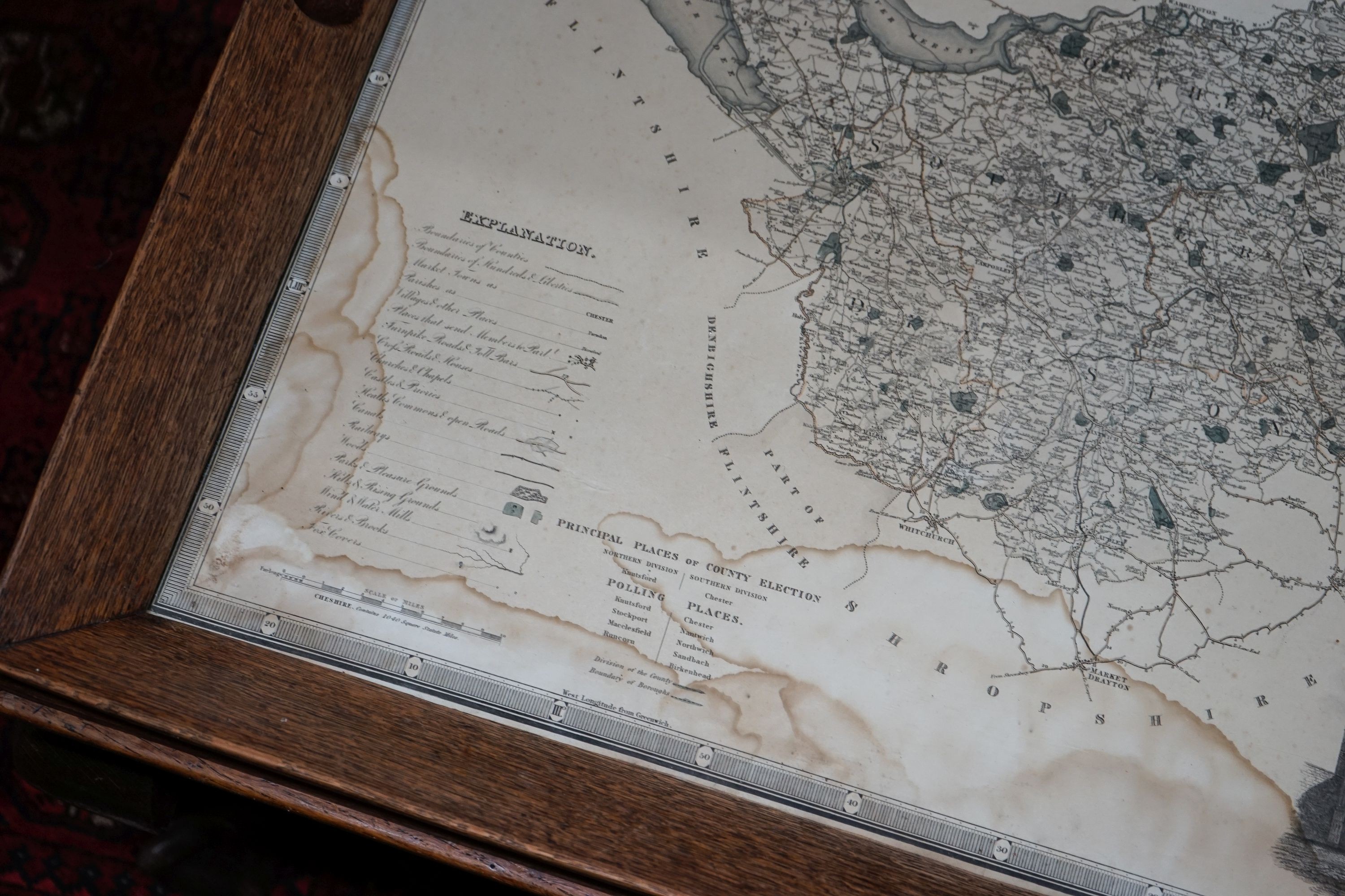 A rectangular oak tray top low table inset with a map of Cheshire on ball and claw stand, width 80cm, depth 70cm, height 48cm